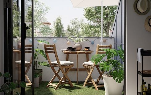 Compact and stylish space-saving balcony furniture set with foldable chairs and a table.