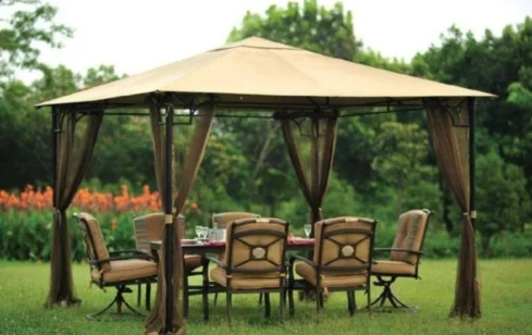 Portable gazebo with elegant outdoor furniture in a lush garden.